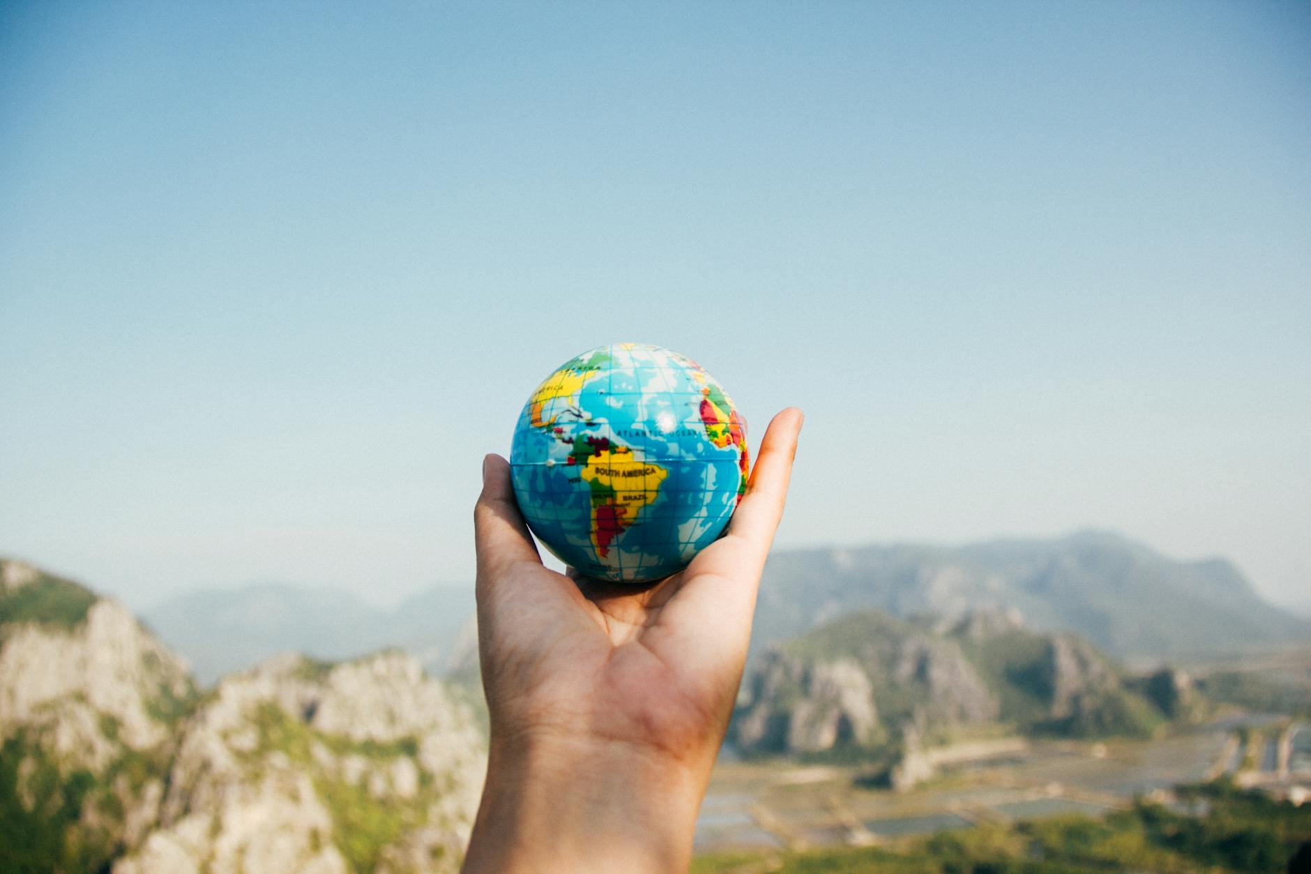 Photo by Porapak Apichodilok on <a href="https://www.pexels.com/photo/person-holding-world-globe-facing-mountain-346885/" rel="nofollow">Pexels.com</a>